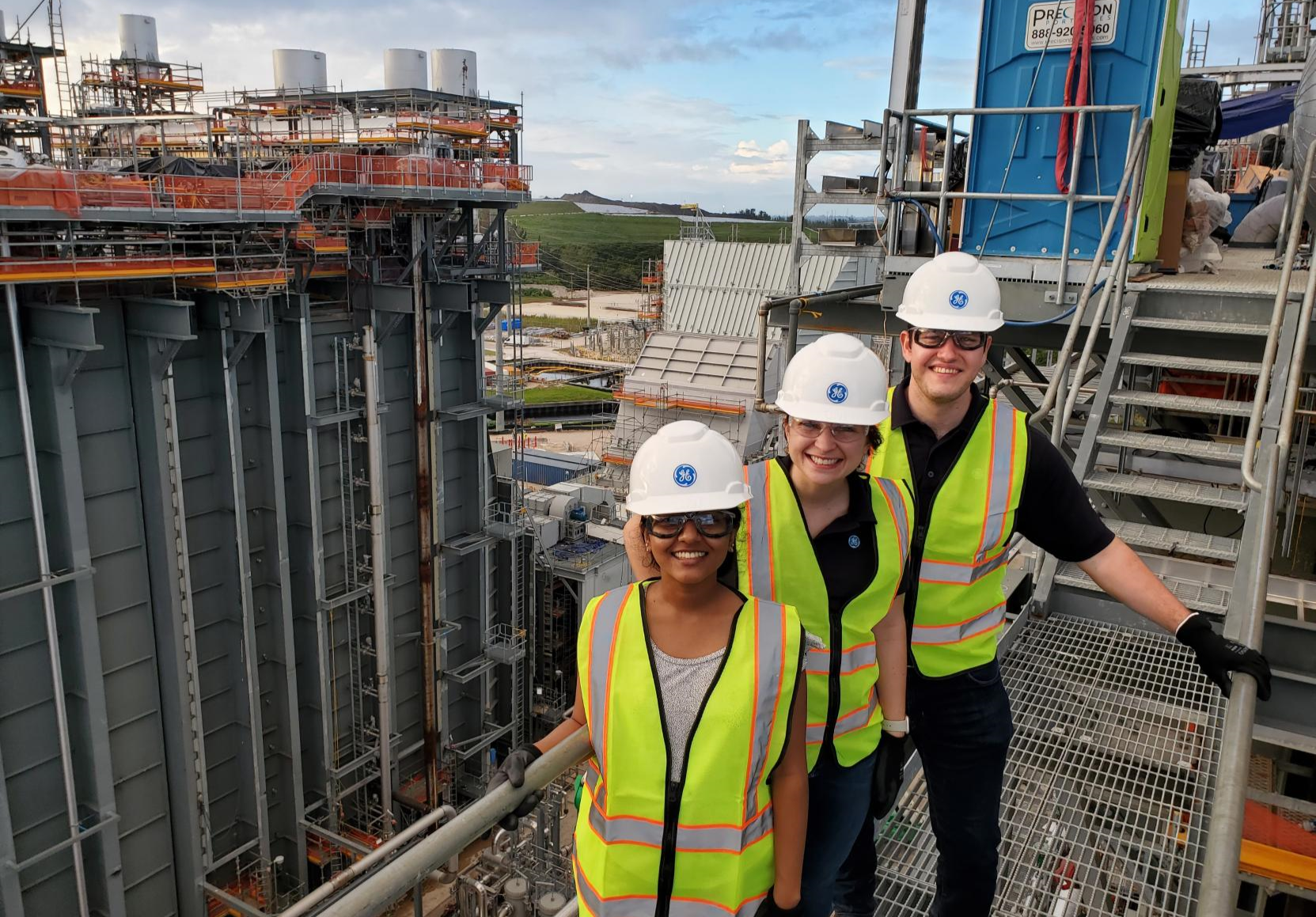 3 people on a worksite in neon vests