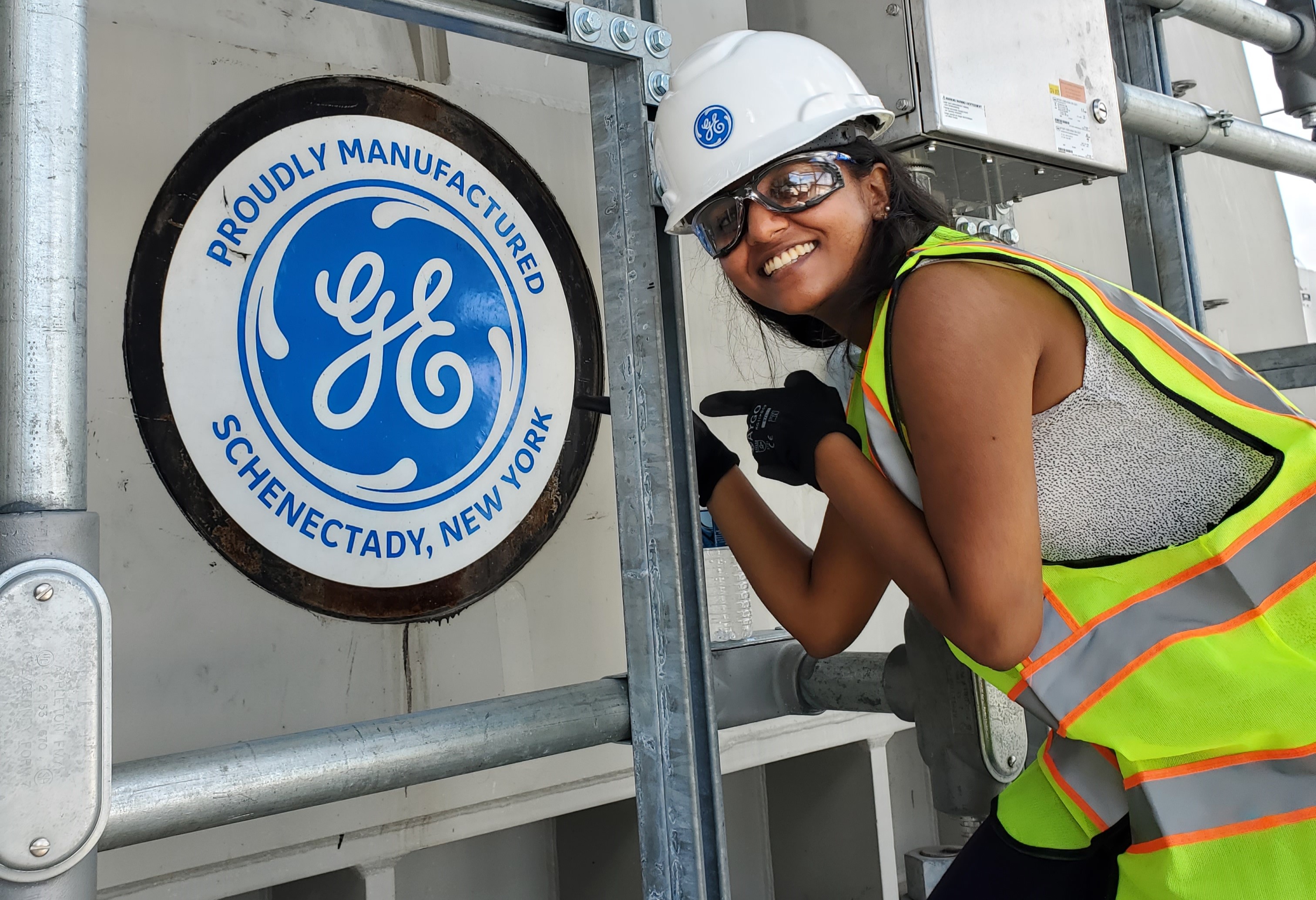 Young woman pointing to a GE Schenectady sign