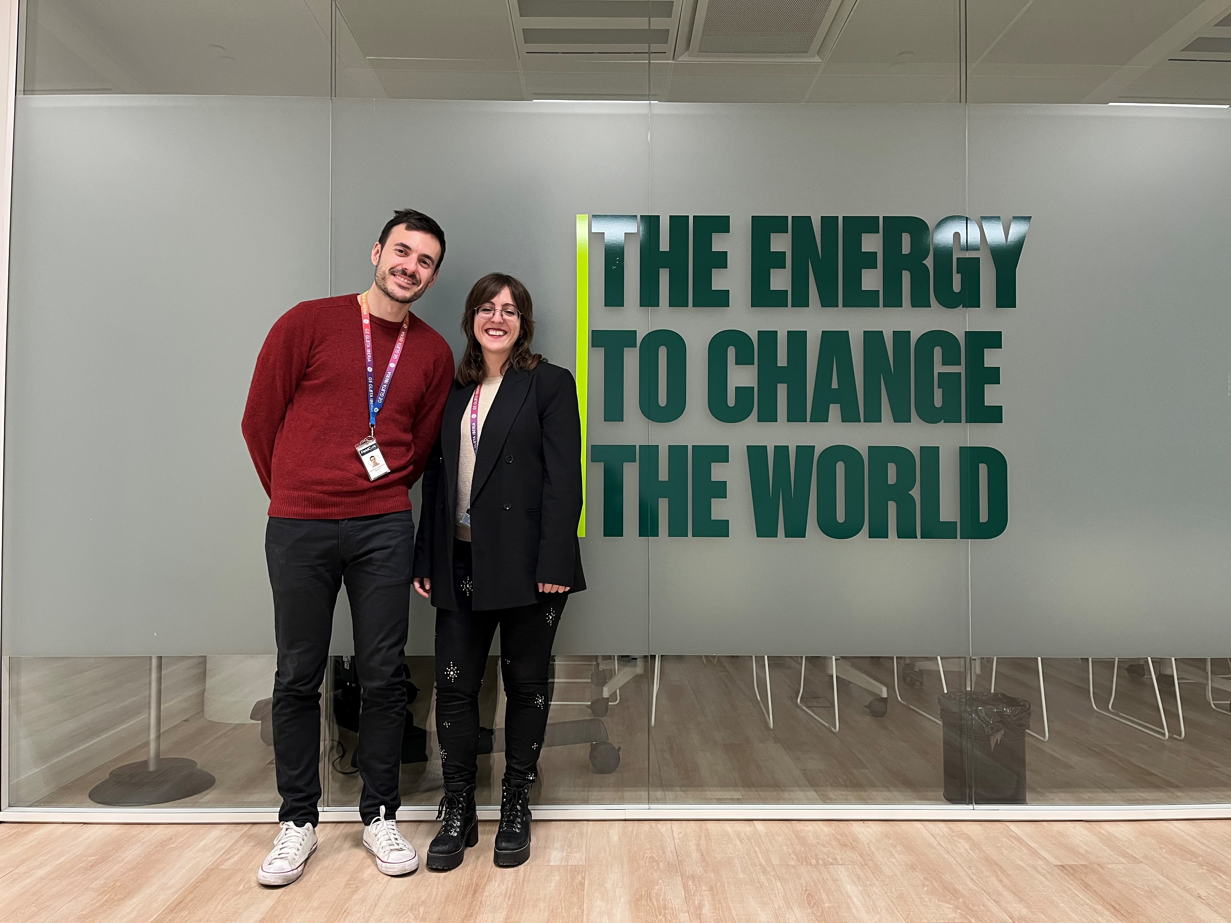 Miguel Angel Herranz del Pino and Paola Campana Sabonet standing in front of a sign that reads "The Energy to Change the World"