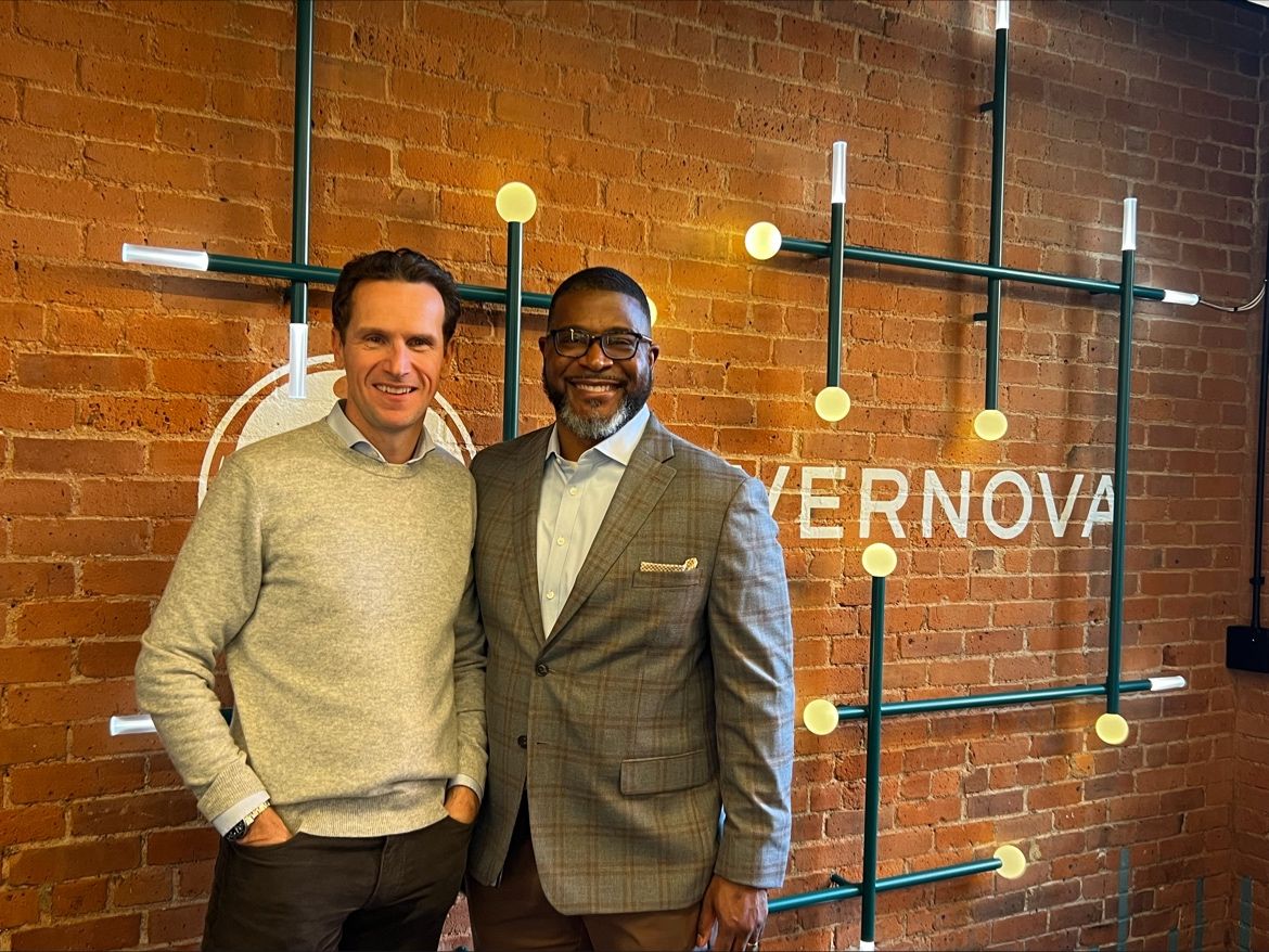 Steven Baert and Reggie Miller standing in front of GEV sign