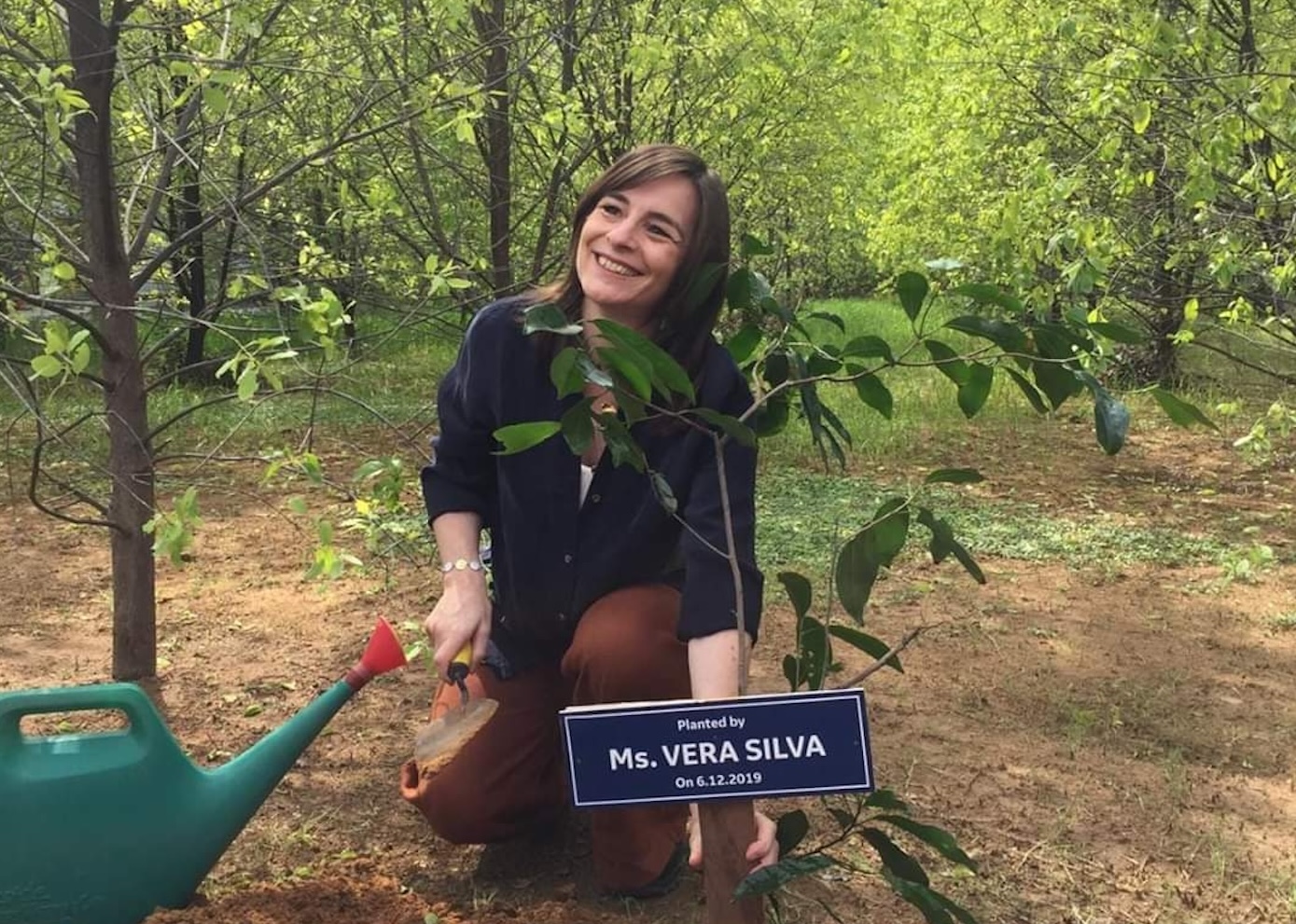 Vera kneeling with sapling