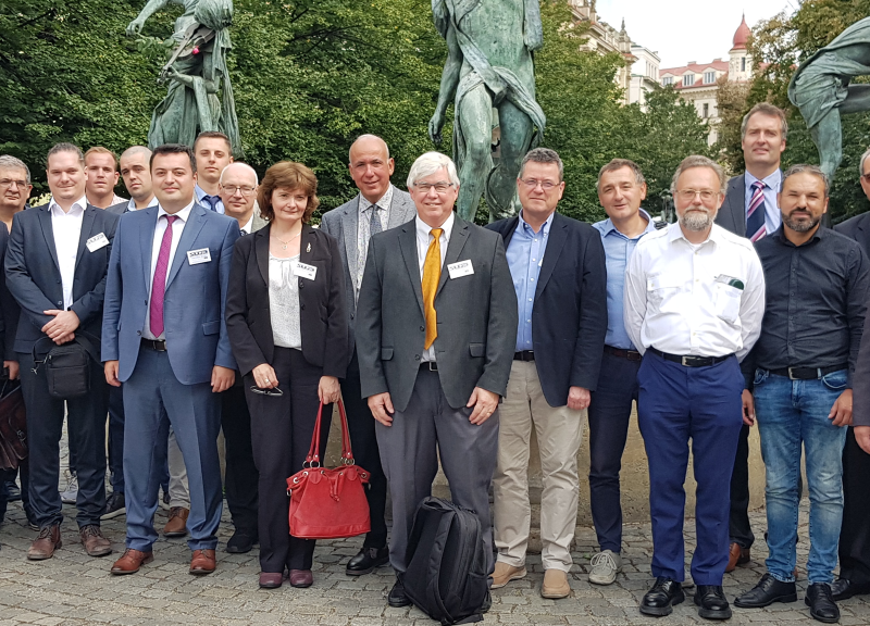 Dennis Henneke standing in front of statue with colleagues